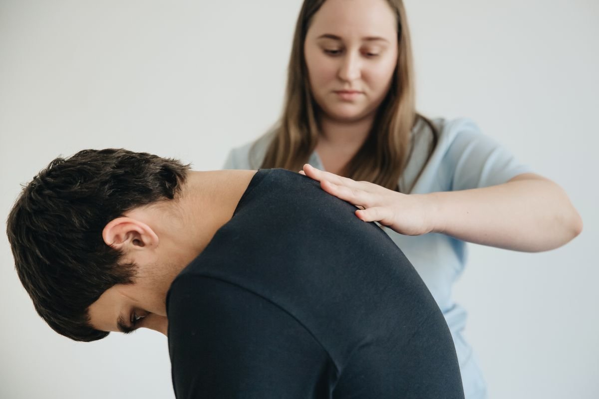 A physiotherapist guiding a patient through a seated mobility exercise